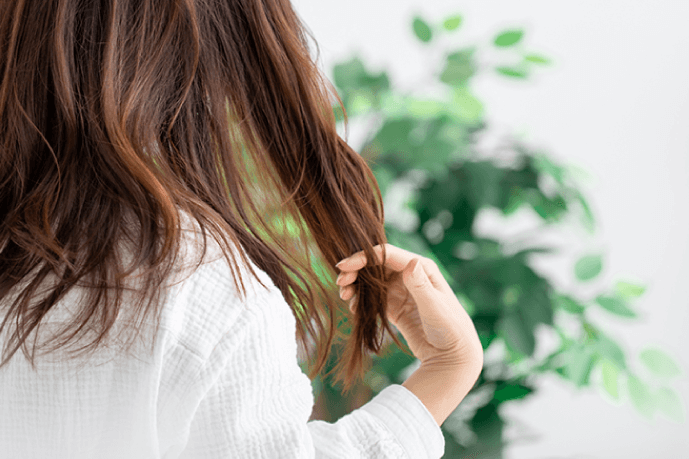 髪の毛を気にする女性